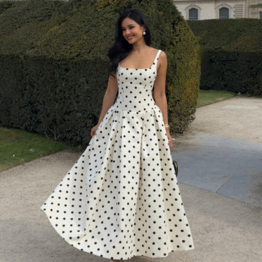Robe longue à pois écru et noir portée lors d'une journée ensoleillée en bord de mer