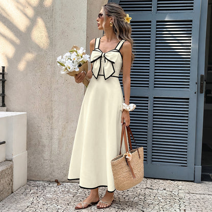Robe d'été longue évasée beige et noire portée avec un panier en paille