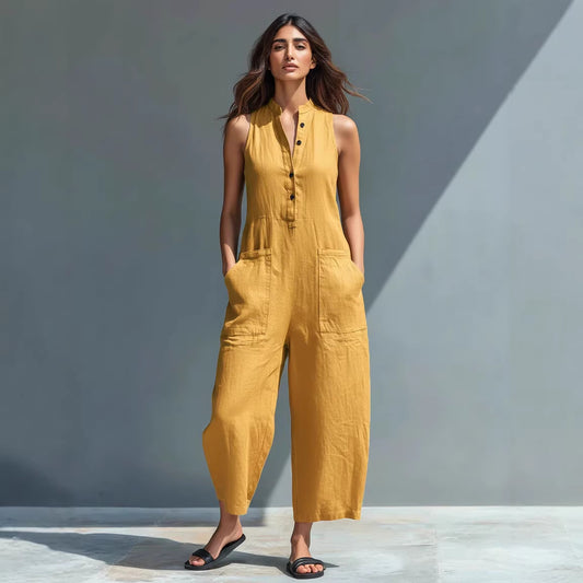 Combinaison pantalon ample sans manches noire portée avec des sandales plates